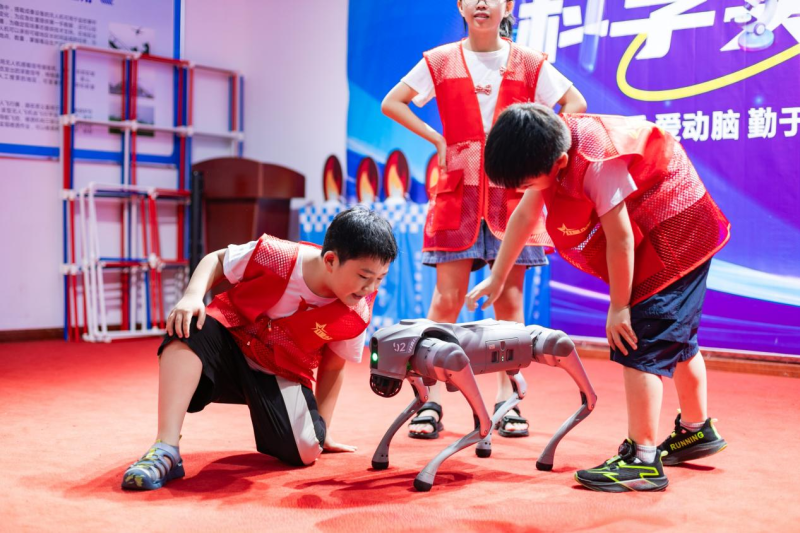 孩子们在老师的指导下操控仿生机械狗。