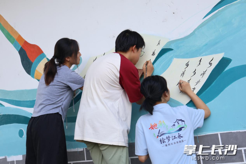 实践团成员结合地方特色进行墙绘工作。