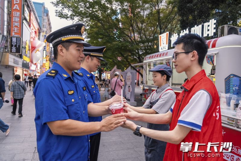 为城管工作人员送上饮品。
