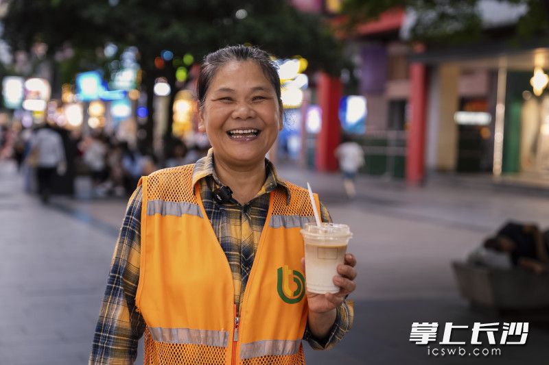 环卫工人刘艳红接过饮品，开心得合不拢嘴。 均为长沙晚报全媒体记者陈飞摄