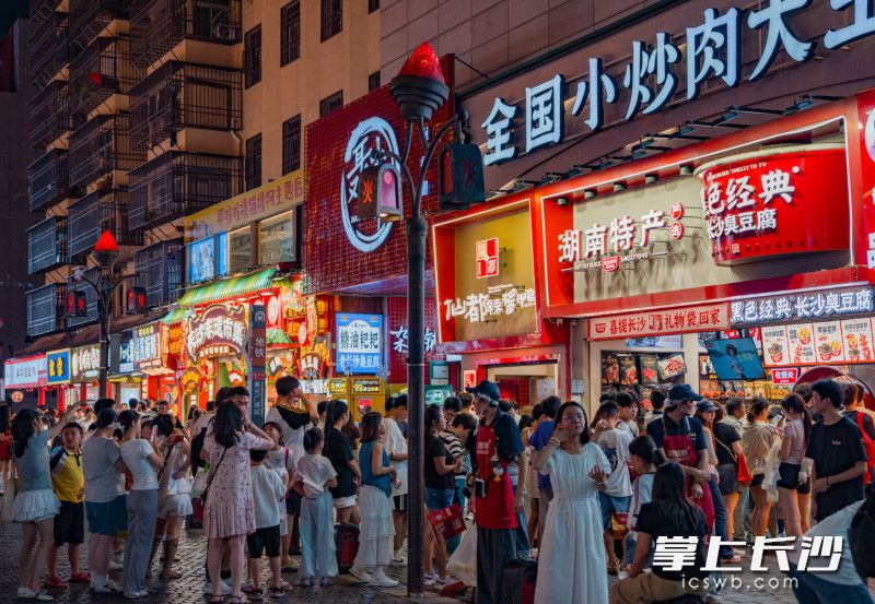 坡子街黑色经典臭豆腐门店前，排队人群都拐两道弯。