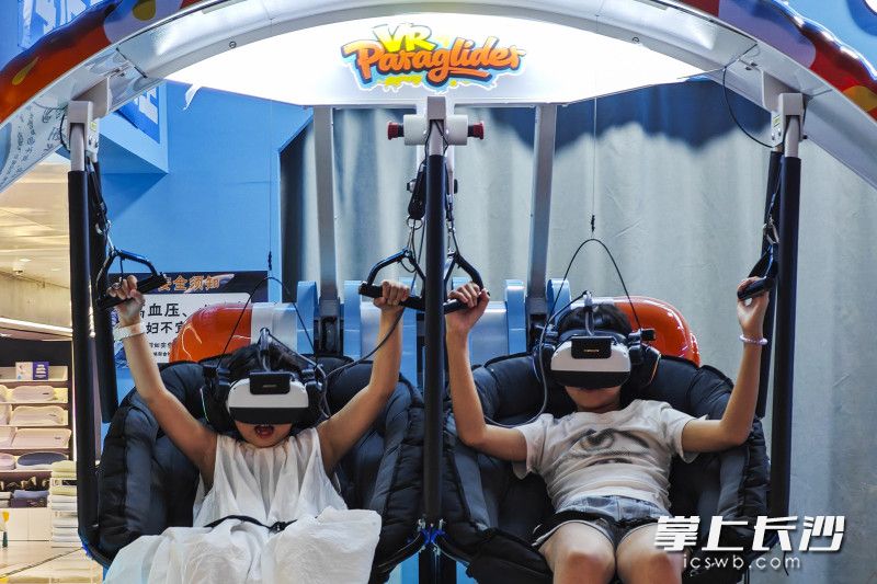 一商场的vr体验馆，两个小孩在体验vr电影。