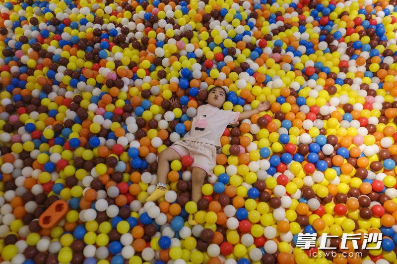 在万家丽国际广场里一处游乐园，一位小孩躺在商场的海洋球里。均为 长沙晚报全媒体记者 黄启晴 摄