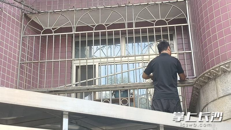 物业工作人员帮助居民拆除封闭防盗窗，破除火灾逃生阻碍。