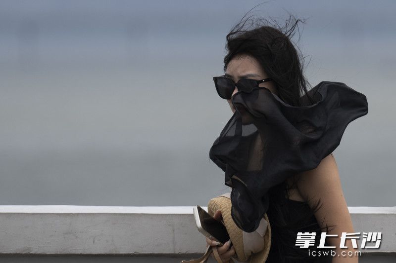 大风吹起一位女士的衣服。