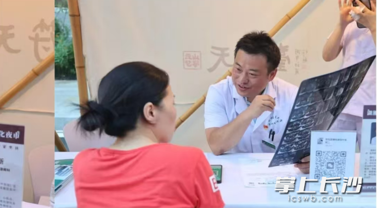 专家在认真向市民解释影像片上显示的病情内容。