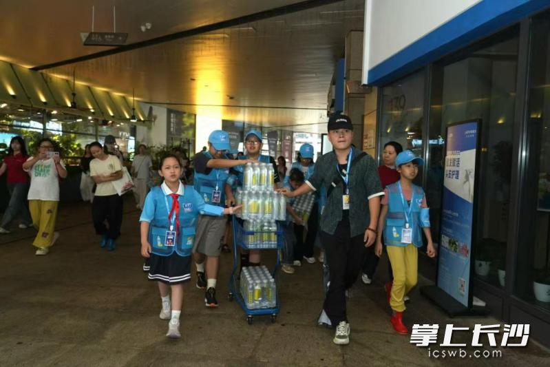 来自长沙各学校的学生化身爱心冰柜 “小小一日站长”，穿上志愿马甲正式上岗。