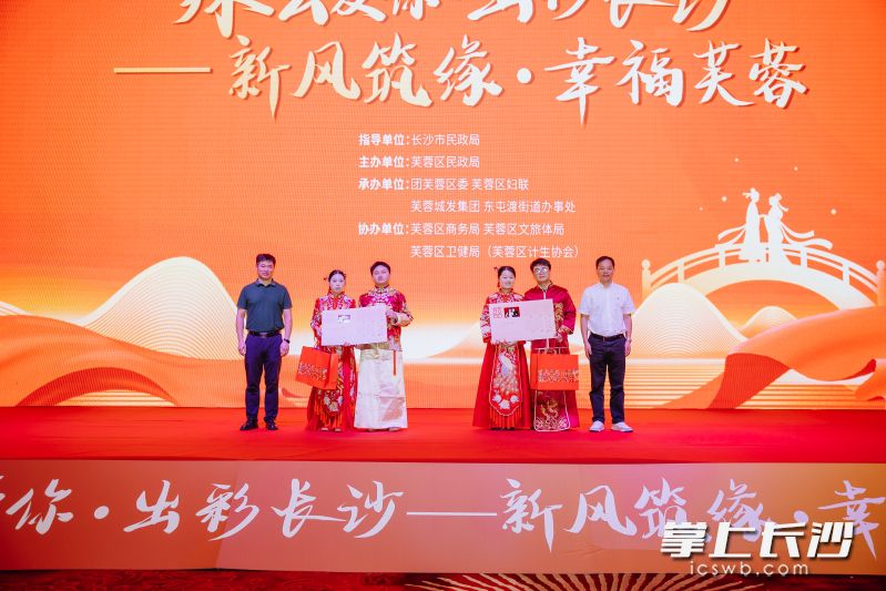 新人携手登台，领取结婚证与文明婚嫁纪念礼品，定格幸福时刻。均为通讯员供图