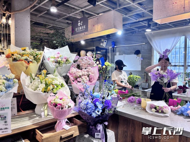 在都市花乡三湘门店里，店员忙着打包花束。 均为长沙晚报全媒体记者贾凯清、实习生吴嘉丽摄