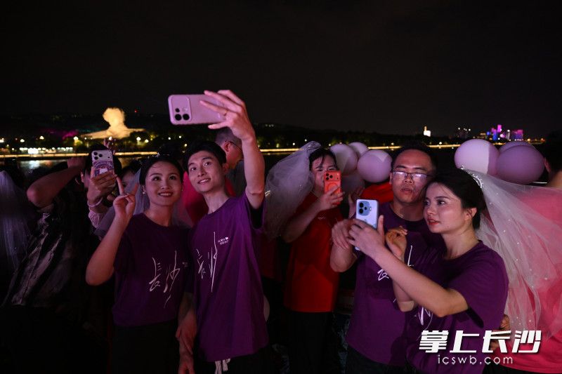 在湘江游轮上，新人们在一江两岸中合影留念。 均为长沙晚报全媒体记者黄启晴摄