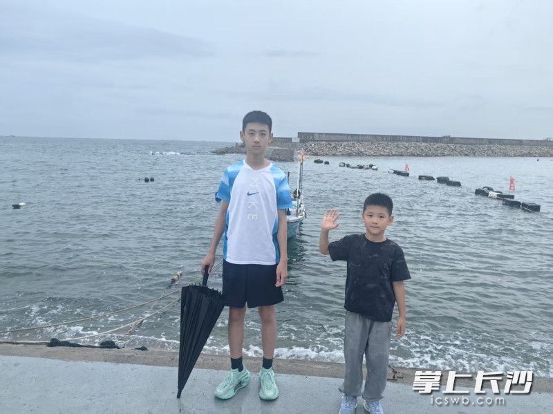 王植兴和弟弟在海边。