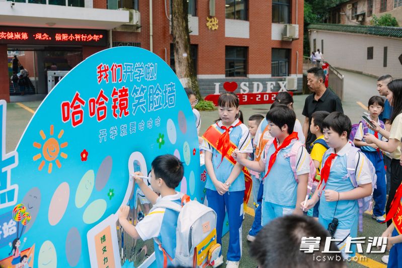 在湖南师范大学附属小学，学生们在哈哈镜和笑脸墙前留下新学期的第一张笑脸。通讯员 王雅涵 供图