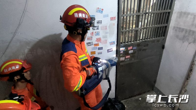 消防员破门营救。 长沙晚报通讯员 黄文平 摄