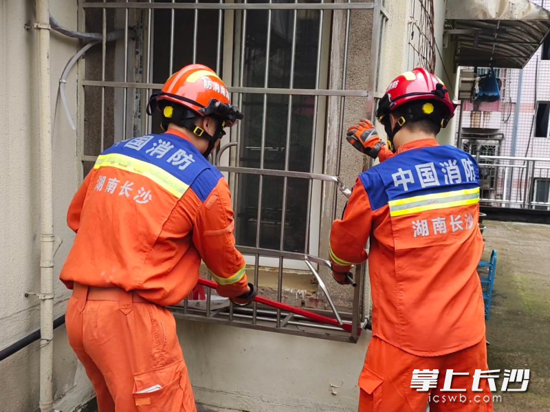 消防员破窗进行救援。长沙晚报通讯员 罗霜操 摄
