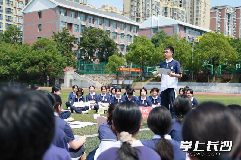 活动中，学生们轮番走到草坪中间，分享暑假研学实践的心得和收获。