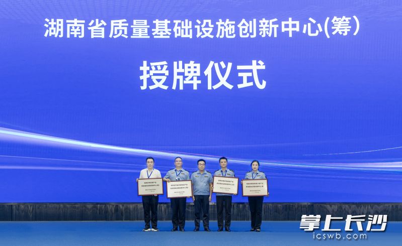 2026年湖南省“质量月”活动启动仪式上，湖南省市场监督管理局党组成员、副局长雷光明（图右3）为4家湖南省质量基础设施创新中心授牌。长沙市市场监管局相关负责人（图右2）接过"湖南省药食同源食品产业质量基础设施创新中心"牌匾。长沙晚报通讯员 周欣 摄