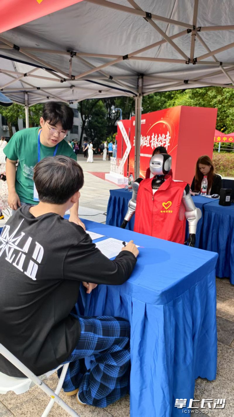 学生志愿者指导新生和“政小智”互动。