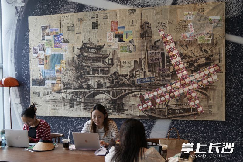 店内的艺术墙吸引了很多人打卡，它是取材老报刊、城市影像搭配臻选豆卡手工拼贴而成。