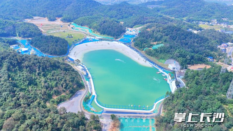 人工湖“牧海”铺展开来，细腻仿真海沙堆砌成浪漫银滩，澄澈湖水衬着远山。