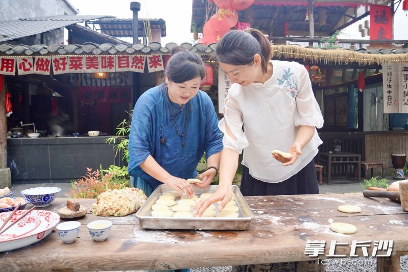 肖凤君（左）指导友人一起制作手工月饼。