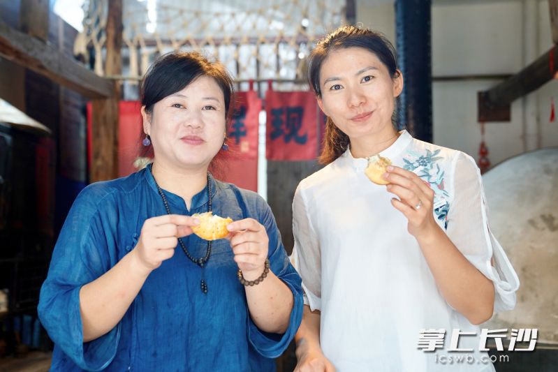 肖凤君（左）和友人品尝刚出炉的月饼。