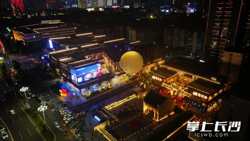 街巷里灯火错落，特色店铺、艺术装置吸引游客驻足打卡。