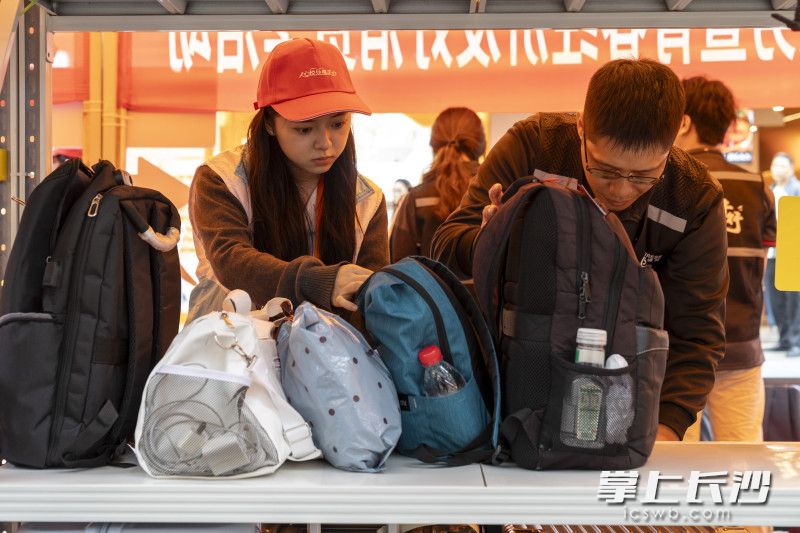 “满天星”志愿者（左）和顺丰小哥（右）在整理行李架。