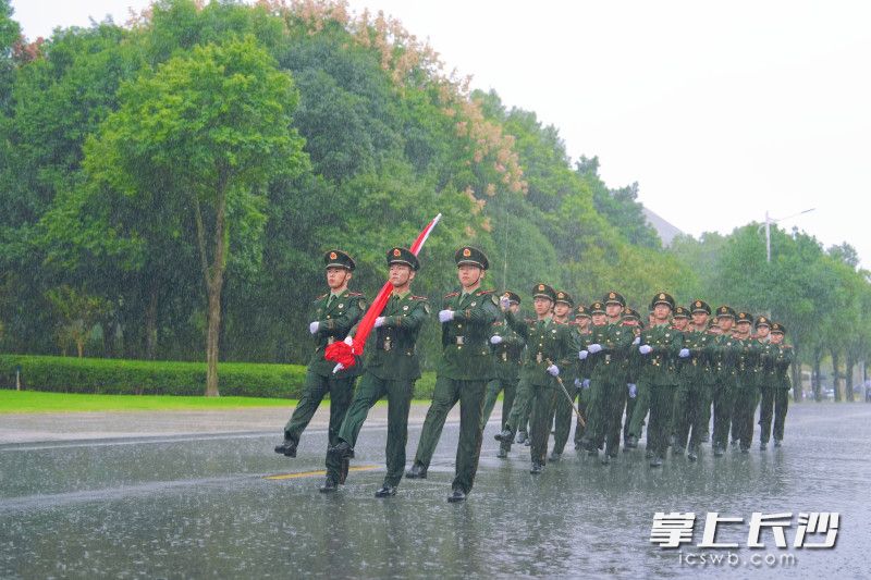 国旗护卫队迈着铿锵有力的步伐走向升旗台。