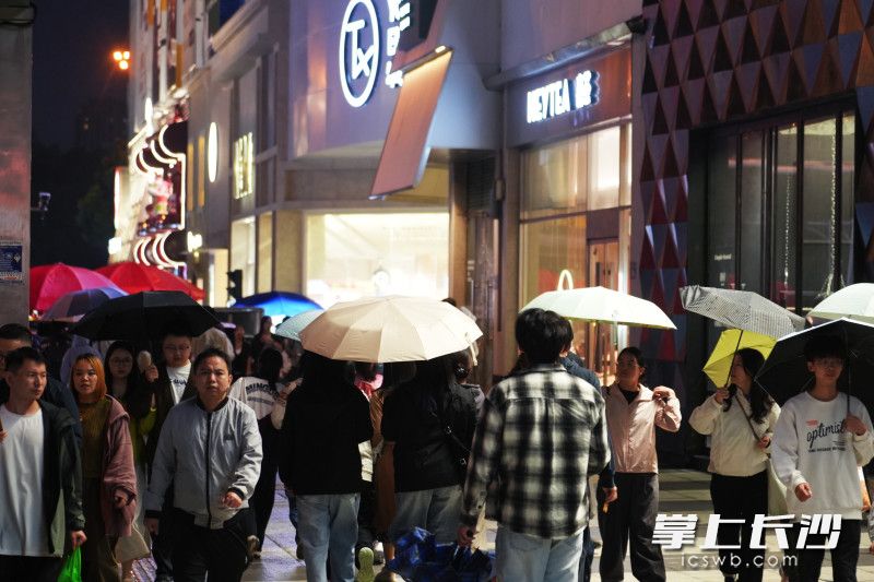 朦胧细雨中，商场门口挤满来来往往的游客。
