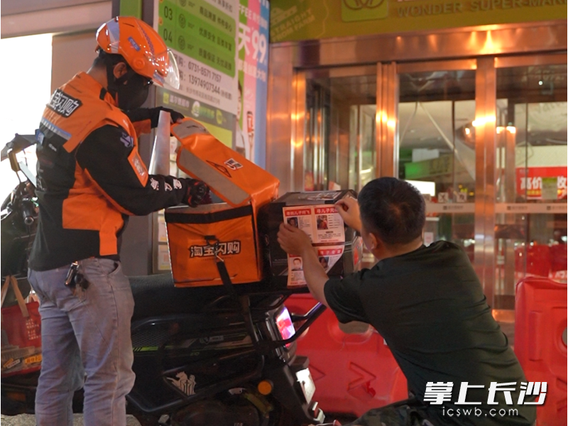 苏朋成在外卖骑手后备箱贴寻亲海报。