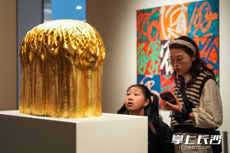 游客目光专注地欣赏展品。 游客目光专注地欣赏展品。