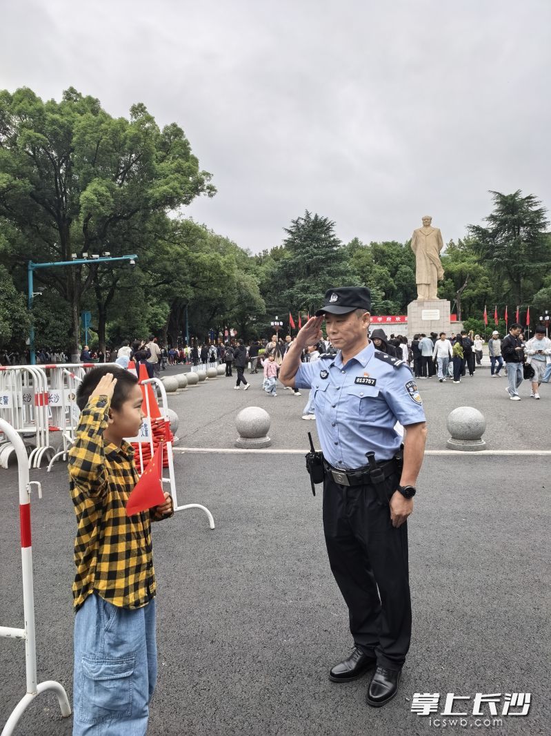 国庆假期，民警坚守岗位，一名小游客向执勤民警敬礼致意。均为通讯员 邓昊雯 供图
