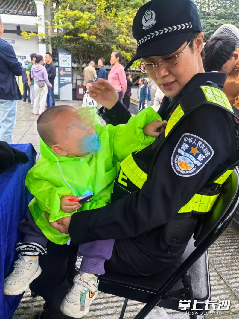 岳麓山景区执勤民警耐心安抚孩子情绪，陪伴其等待家人。
