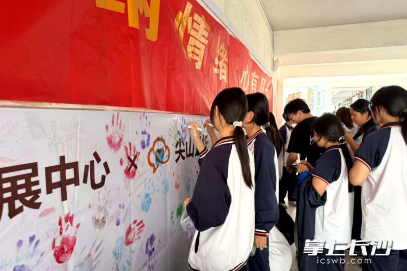 同学们挑选颜料，用掌印和寄语，表达自己的情绪和心愿。