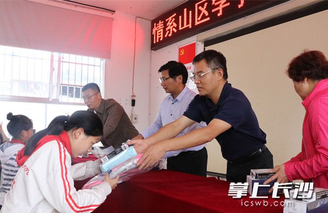 长沙学院博士团队向龙山学生赠送书本。长沙晚报通讯员朱珊供图