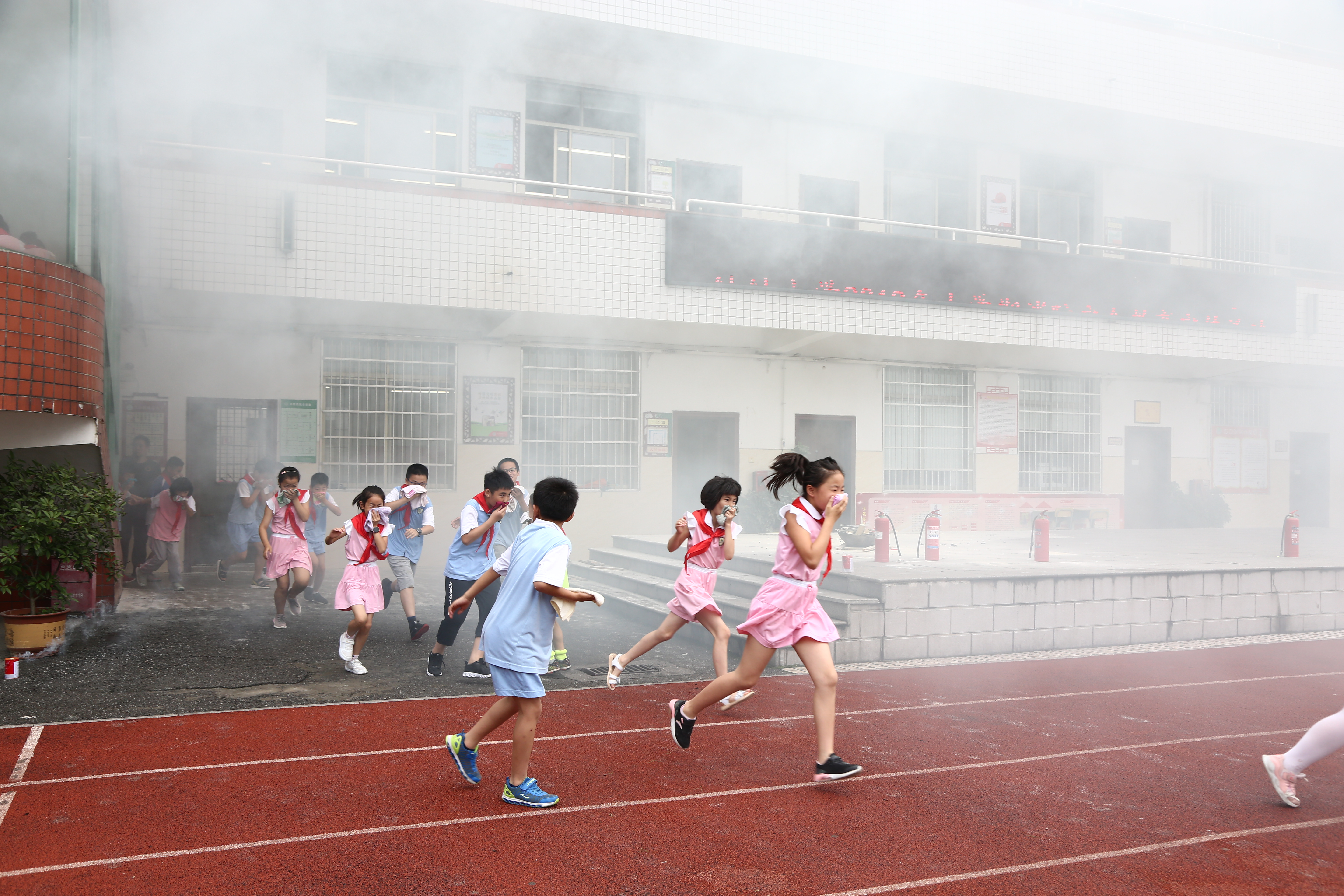 幼幼小学疏散演练现场，孩子们用湿毛巾捂住口鼻，有序撤离至安全区域。长沙晚报通讯员 向娟 供图