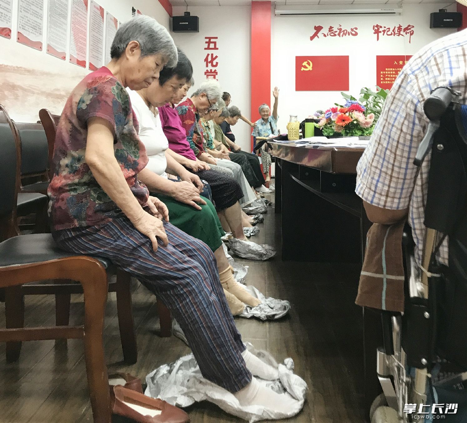 老人们进行撑报纸测试双脚控制力。