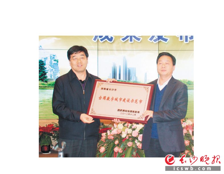 2012年12月14日，数字长沙地理空间框架建设项目成果发布会上，时任长沙市副市长何寄华（右）从国家测绘地理信息局副局长李维森（左）手中接过“全国数字城市建设示范市”奖牌。均为资料图片