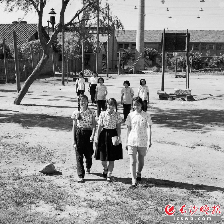 1959年7月7日，农业机械厂的青年职工走过操场准备文化补习。这一年，长沙市青年职工教育实现了基本无文盲的目标。全市工厂、企业的业余学校发展到了321所，参加文化学习的职工达7万人次。