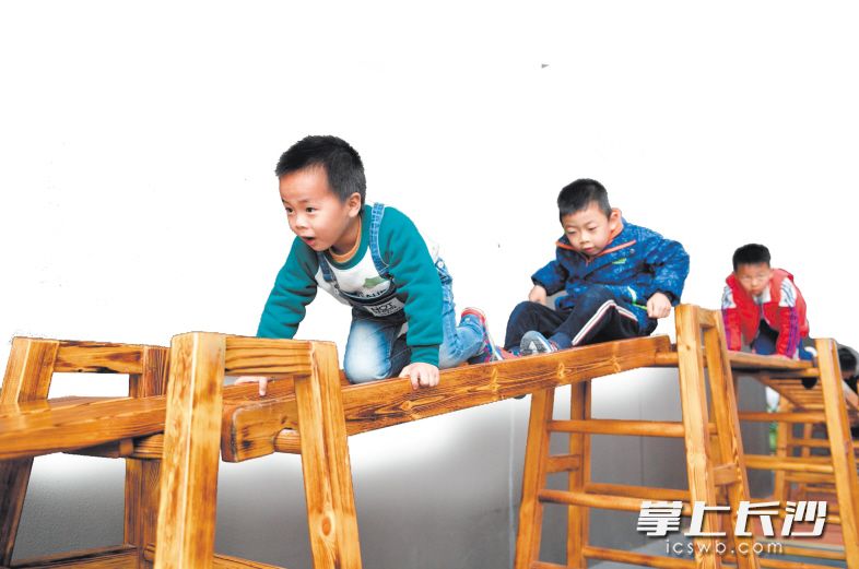师大滨江幼儿园，孩子们在爬小木桥。图片均为长沙晚报全媒体记者 邹麟 摄