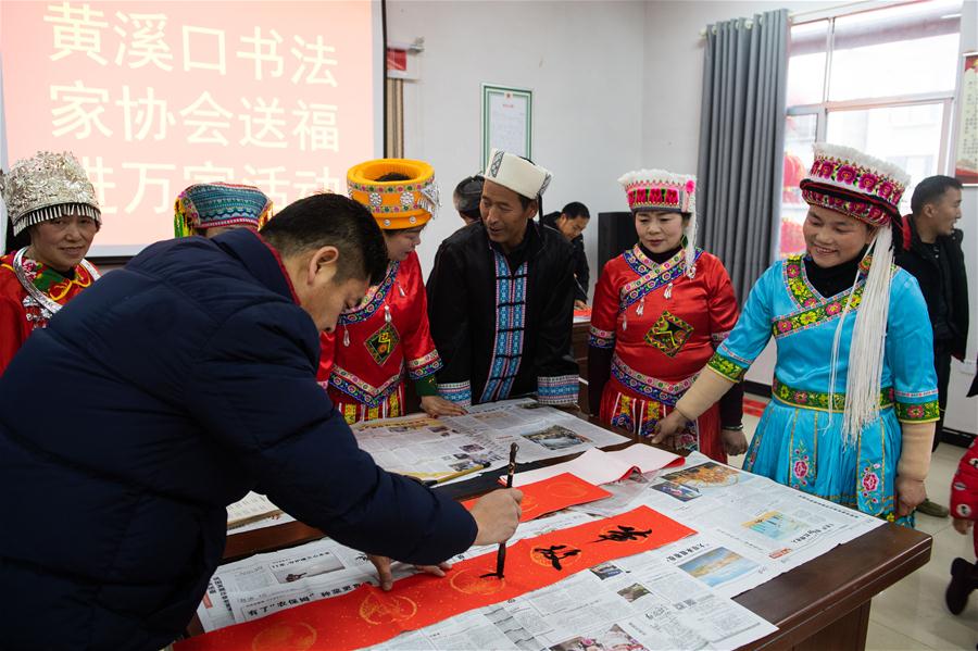 1月15日，在湖南省辰溪县双溪村，黄溪口书法家协会组织会员为村民送对联。 新华社发（陈思汗摄）