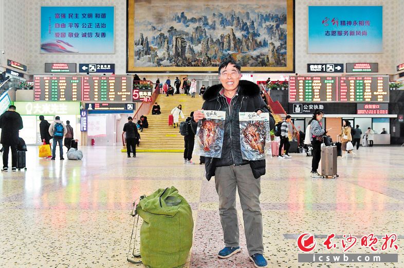 　　16日下午，长沙火车站内，来自河南永城的郭德恒拿出给家人带的湖南酱板鱼。长沙晚报全媒体记者 王志伟 实习生 唐纯镁 摄影报道
