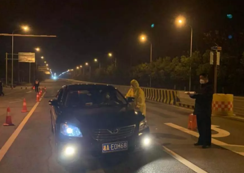 谭哲在芙蓉北路长沙与岳阳交界处谭家园路口段驻守查控车辆做记录。