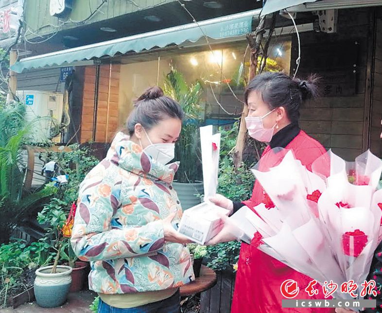 牛角塘社区的党员为辖内门店女老板送上口罩和鲜花。 长沙晚报全媒体记者 胡媛媛 摄