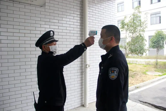 劳安科科长程曙光在为值班警察测量体温