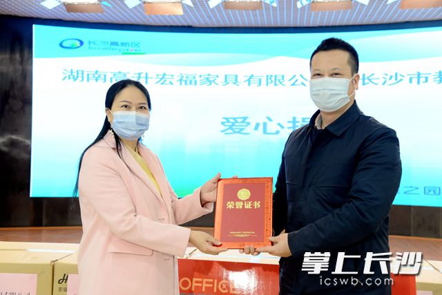 长沙市教育局副局长杨庆江（右）将爱心捐赠证书交到高升宏福董事长谢沛吾（左）手中。周秋燕 摄
