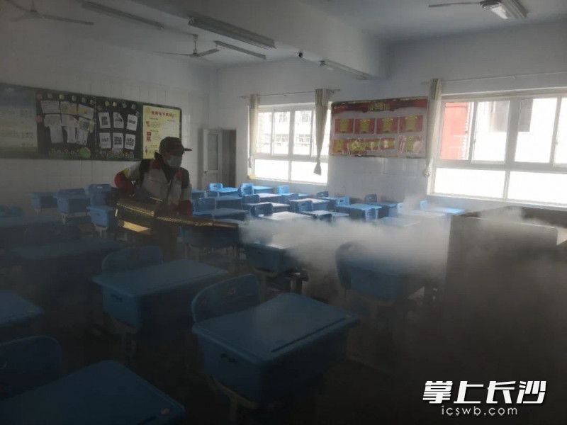 雨花区育新小学，防疫人员正在对进校人员测量体温和教室消毒。