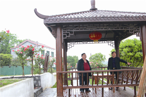 村民向建国(左)和村干部在交流美丽屋场建设发展规划。