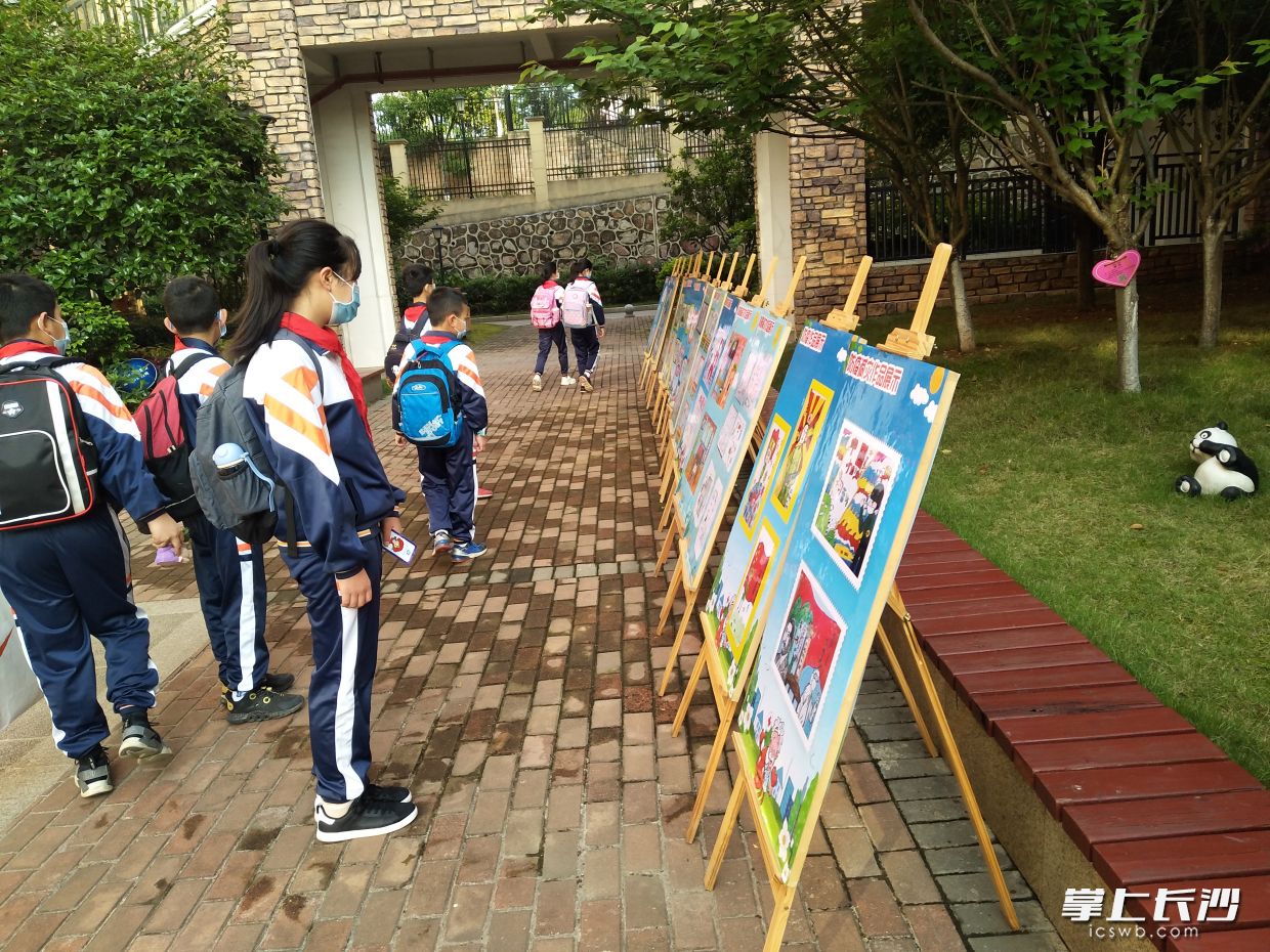 几名同学在参观同学们自己创作的抗疫作品。
