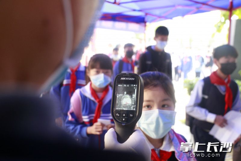 砂子塘万境水岸小学学生进校测体温。